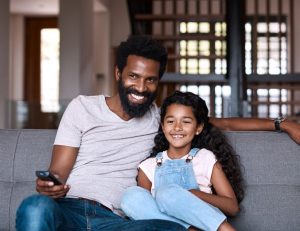 father and daughter watching tv in subsahara africa