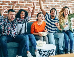 young people watching a game on tv