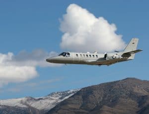 military aircraft flying over mountain range