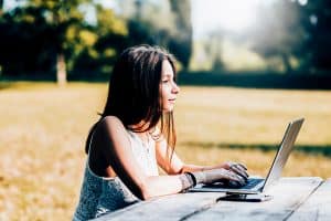 woman in park on laptop